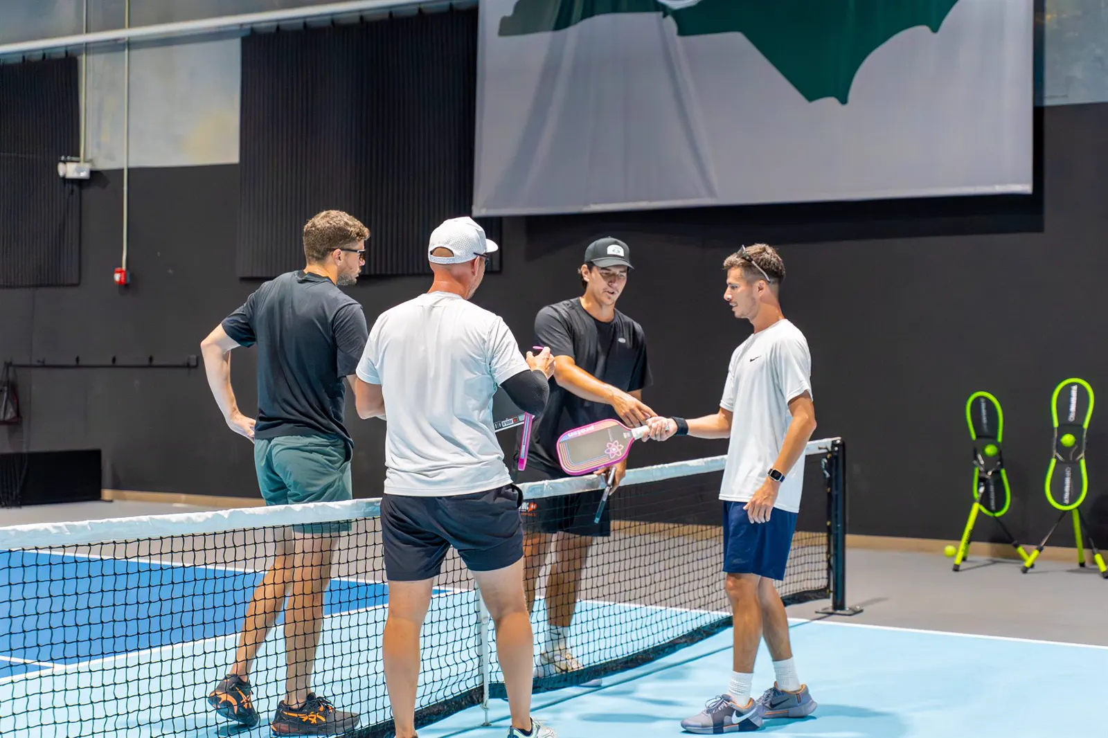 Players gathered at the net during a focused pickleball training session