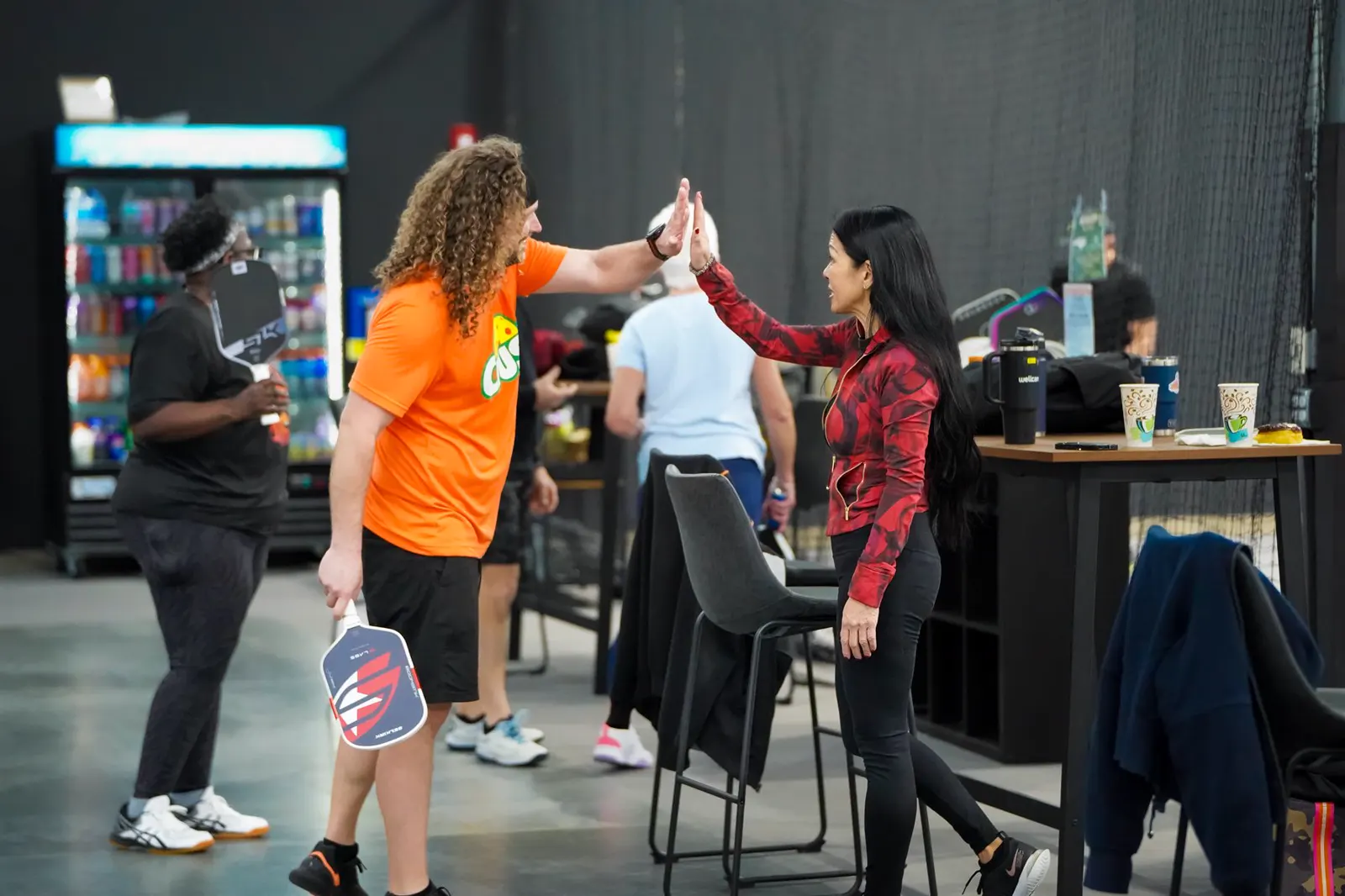Players high-fiving during a social pickleball event
