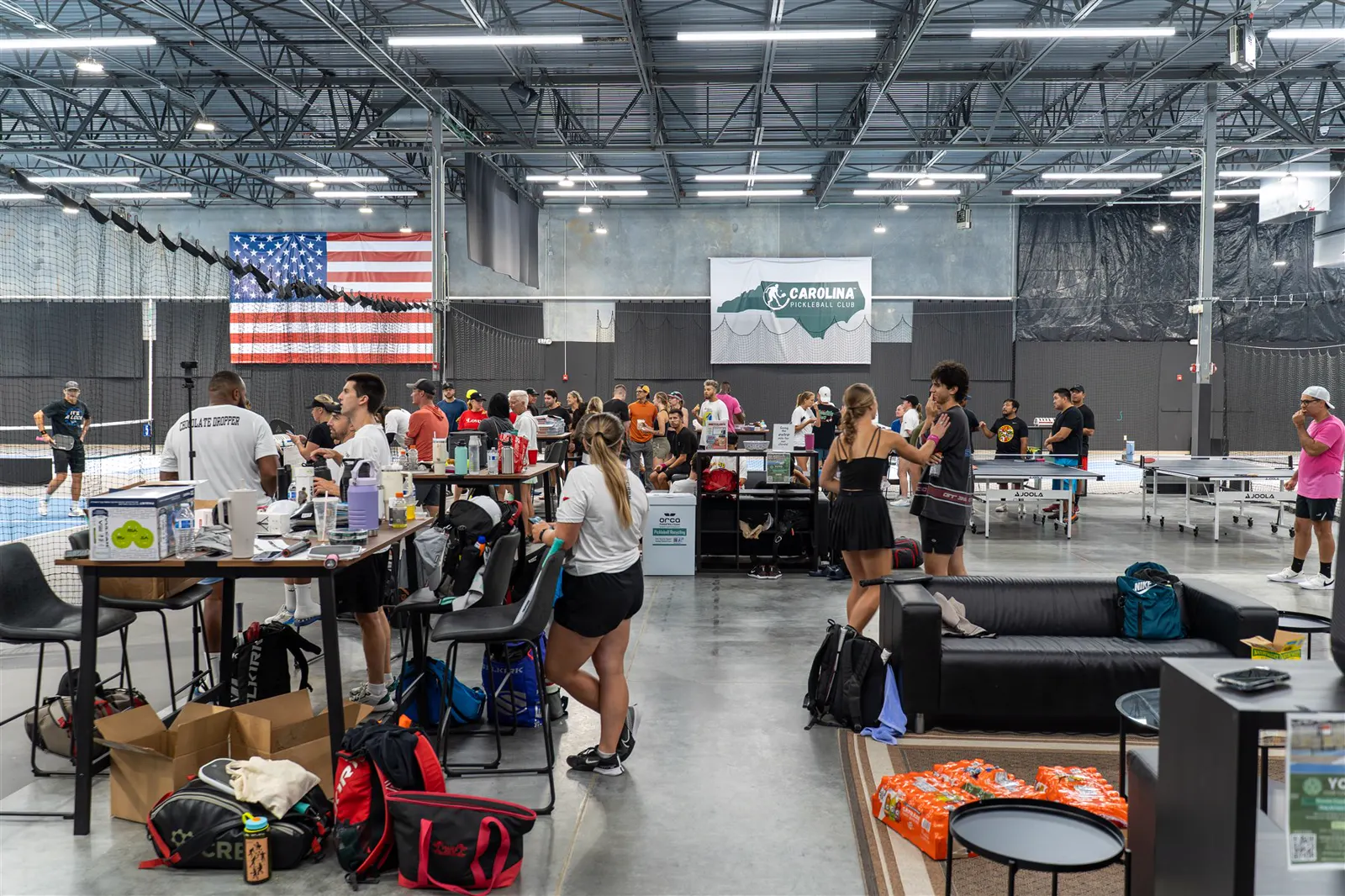 An indoor Carolina Pickleball Club tournament scene with players and spectators