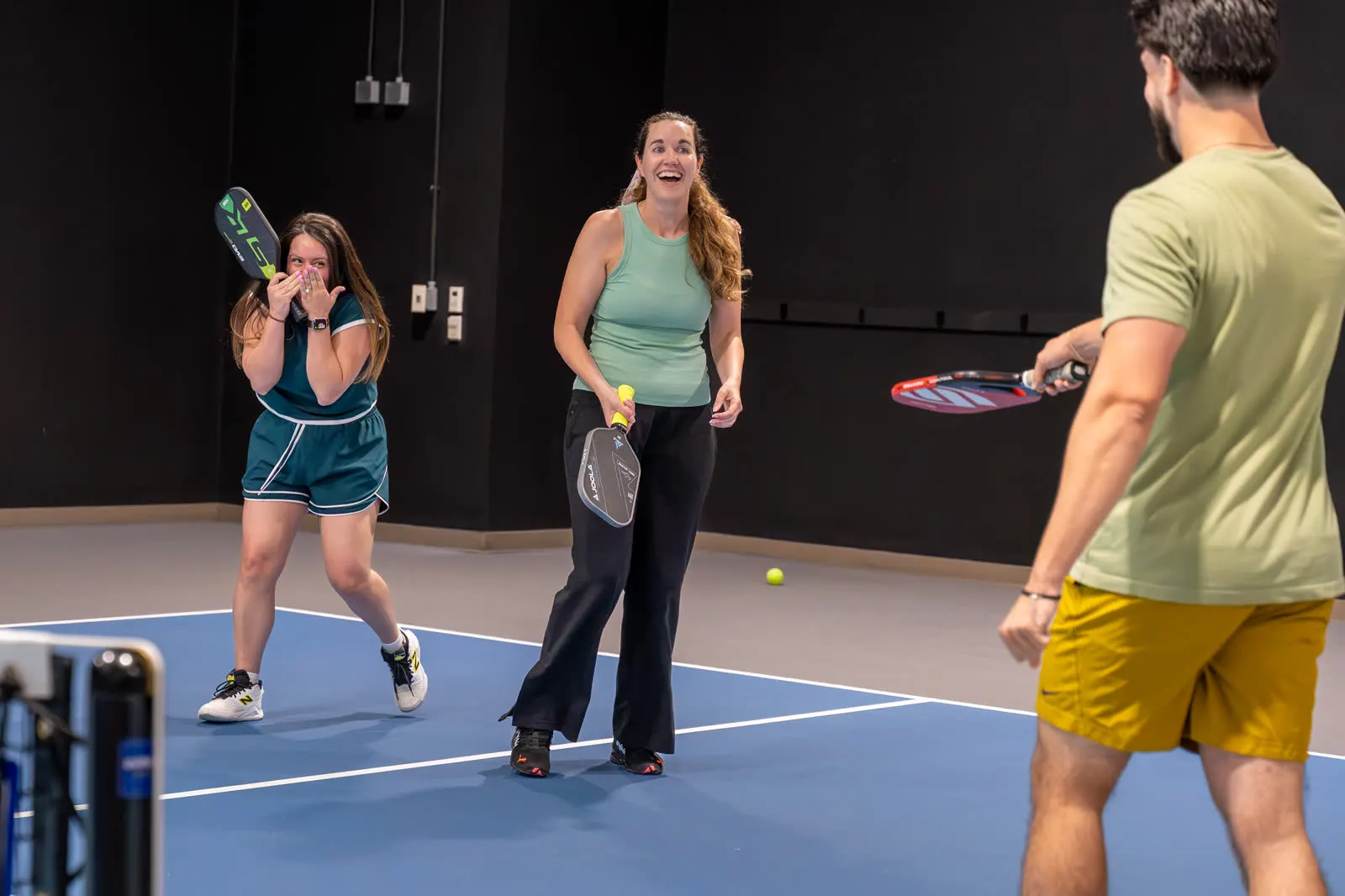 Players smiling during an indoor pickleball session at Carolina Pickleball Club.